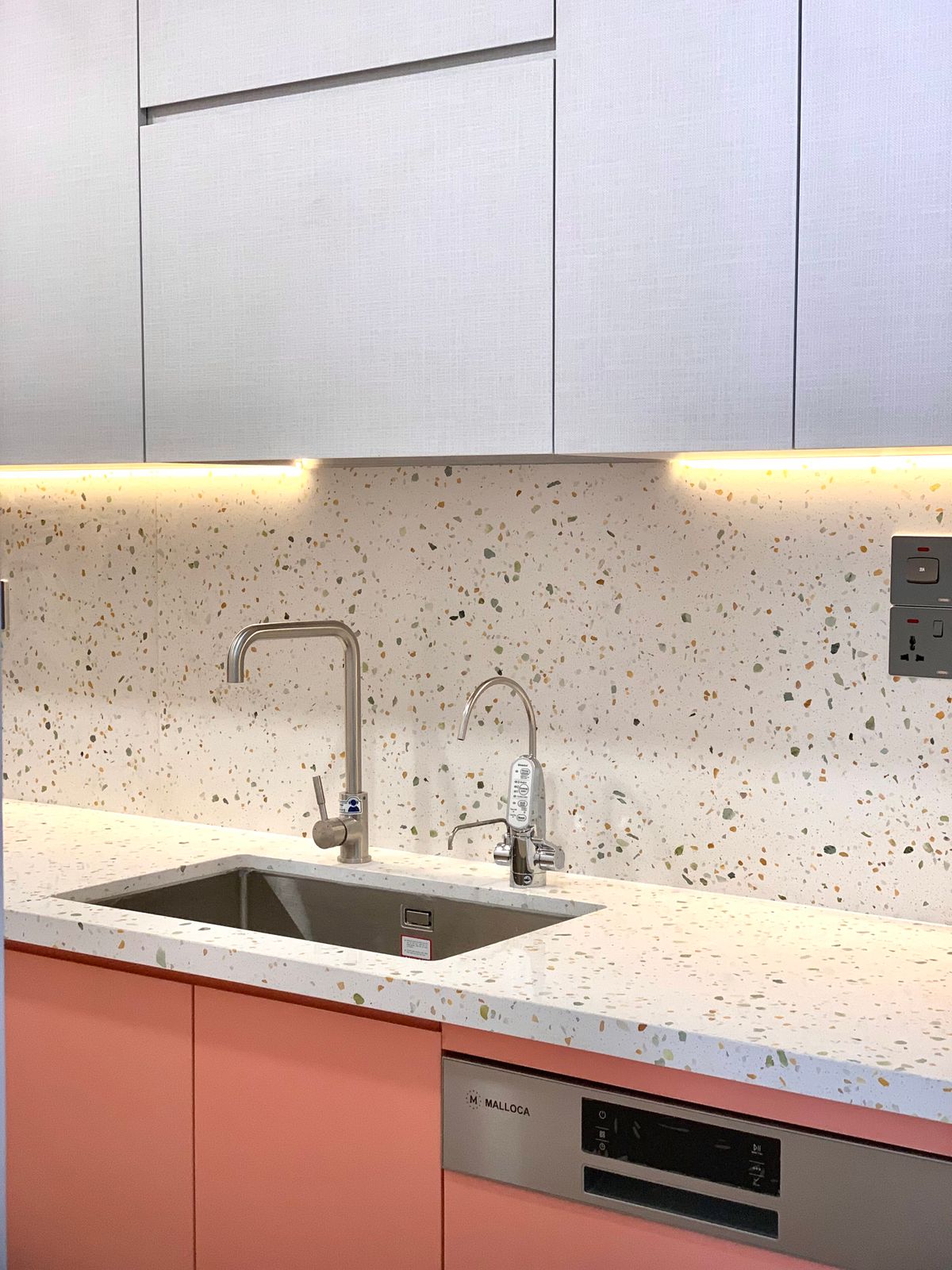 Stainless steel kitchen sink set into a terrazzo countertop
